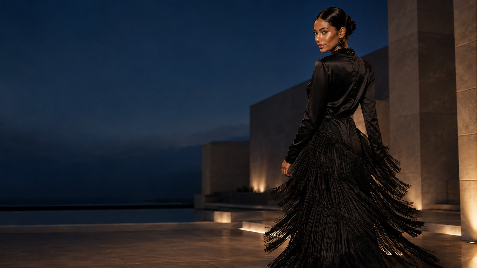 Woman in a black dress standing in a dimly lit architectural setting
